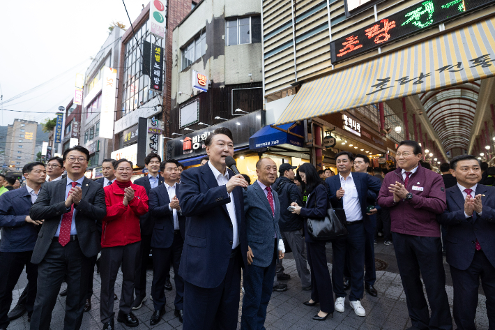 윤석열 대통령이 22일 부산역 인근 전통시장인 초량시장을 방문해 시장을 찾은 시민과 상인들에게 격려의 말을 전하고 있다. 연합뉴스