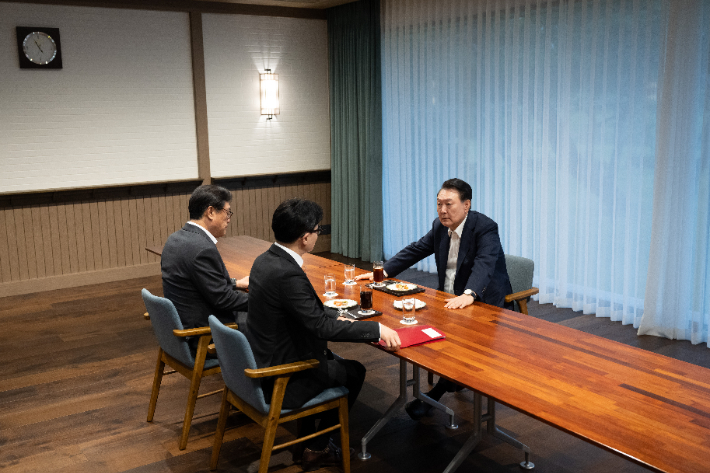 윤석열 대통령이 21일 서울 용산 대통령실 앞 파인그라스에서 국민의힘 한동훈 대표를 만나 대화하고 있다. 대통령실 제공