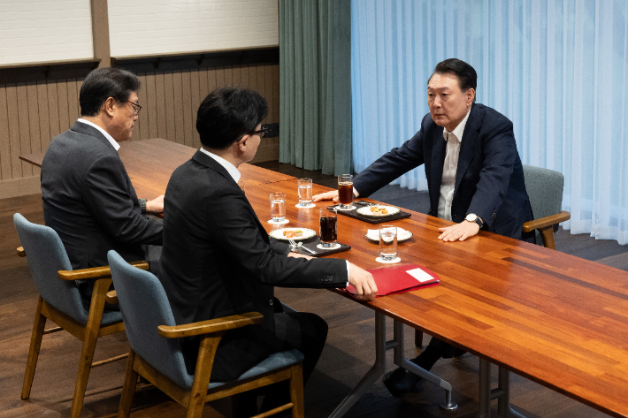 윤석열 대통령이 21일 서울 용산 대통령실 앞 파인그라스에서 국민의힘 한동훈 대표를 만나 대화하고 있다. 이 자리에는 정진석 대통령 비서실장이 배석했다. 대통령실 제공