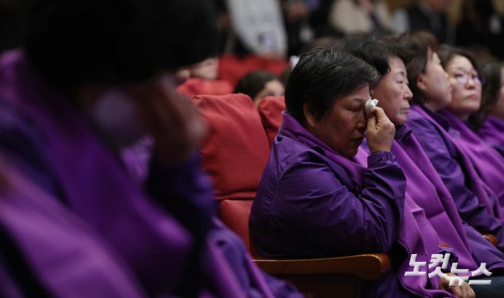 29일 국회에서 열린 10·29 이태원참사 2주기 추모식에서 유가족들이 희생자들의 영정에 헌화한 뒤 눈물을 흘리고 있다.