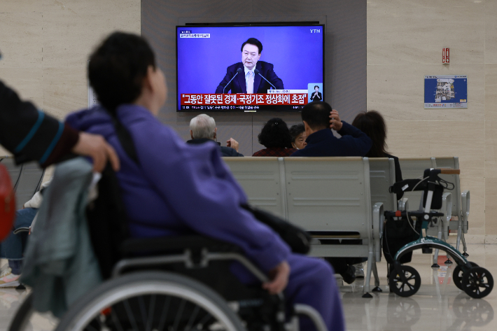 7일 오전 서울 시내 한 대학병원에 설치된 텔레비전으로 내원객이 윤석열 대통령 대국민 담화 중계를 지켜보고 있다. 연합뉴스