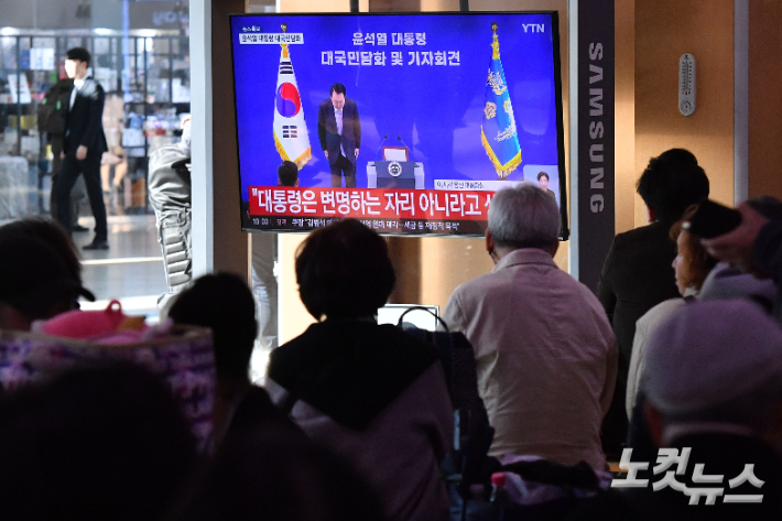 지난 7일 서울 중구 서울역 대합실에서 시민들이 윤석열 대통령의 대국민 담화 및 기자회견을 지켜보고 있는 모습. 류영주 기자