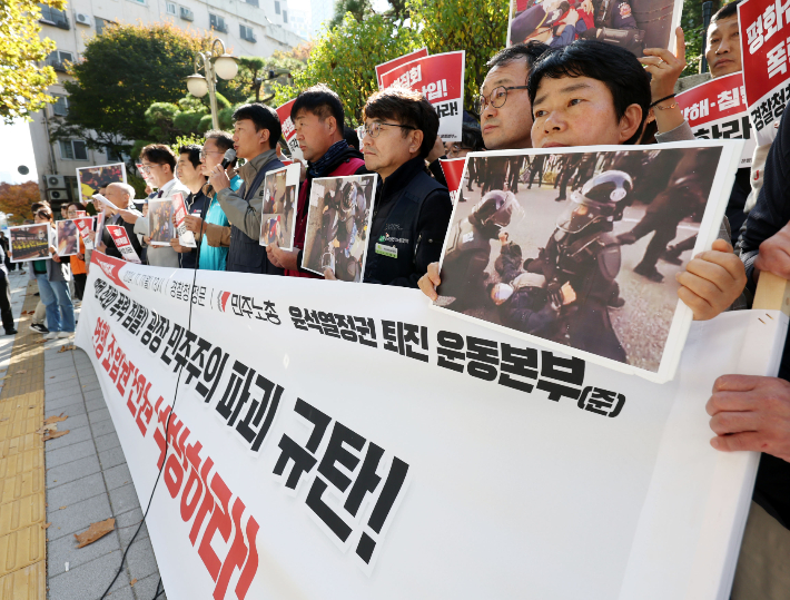 민주노총 조합원들이 11일 오후 서울 서대문구 경찰청 앞에서 기자회견을 열고 지난 9일 개최된 도심 집회에서 연행된 조합원 전원을 석방해줄 것을 촉구하며 손팻말을 들고 있다. 연합뉴스