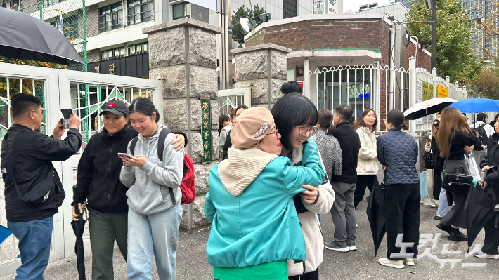 14일 서울 광남고등학교 앞에서 손녀를 껴안고 있는 할머니의 모습. 박인 기자