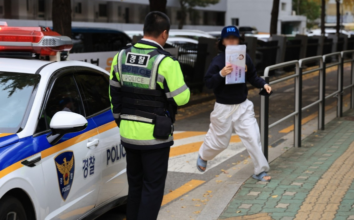 2025학년도 대학수학능력시험(수능)이 치러진 14일 오전 서울 영등포구 여의도여고에서 가족이 경찰차를 타고 와 동생의 수험표를 가져다주고 있다. 연합뉴스