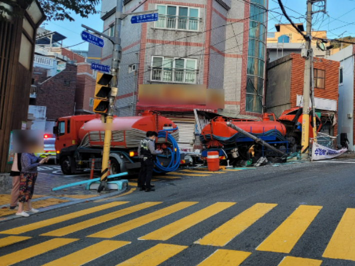 12일 부산 동구의 한 어린이보호구역에서 5t 정화조 차량이 상가 건물과 전신주 등을 들이받은 모습. 부산경찰청 제공 