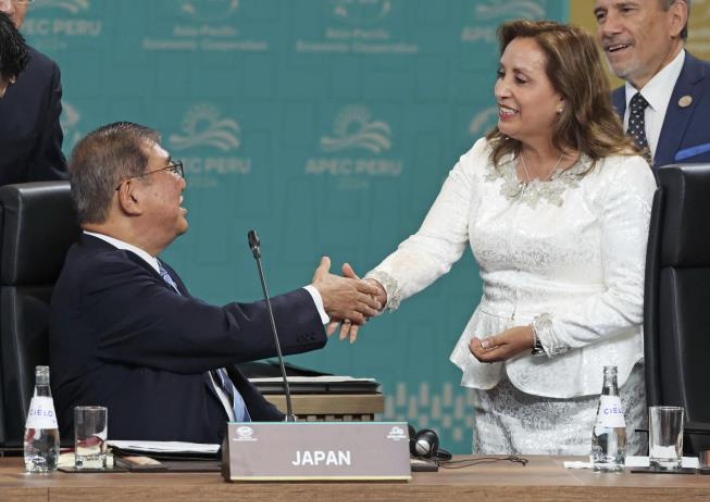 15일 APEC 정상회의 때 앉아서 페루 대통령과 악수하는 이시바(왼쪽) 일본 총리. 연합뉴스