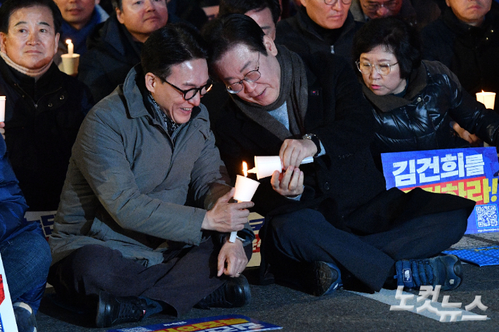 더불어민주당 이재명 대표가 23일 오후 서울 종로구 광화문 북측광장 인근에서 열린 '김건희·윤석열 국정농단 규탄·특검 촉구 제4차 국민행동의 날' 집회에 참석해 김민석 최고위원과 촛불을 나누고 있다. 류영주 기자