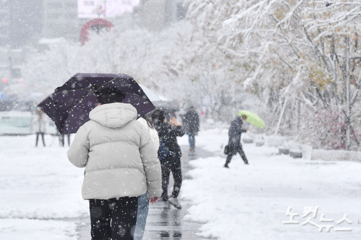 서울 전역에 대설주의보가 발효된 27일 오전 서울 종로구 광화문광장에서 시민들이 조심스레 발걸음을 옮기고 있다. 류영주 기자