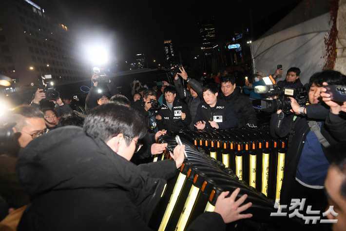 윤석열 대통령이 비상계엄을 선포한 3일 밤 서울 여의도 국회 출입문에서 국회 관계자와 경찰이 대치하고 있다. 박종민 기자