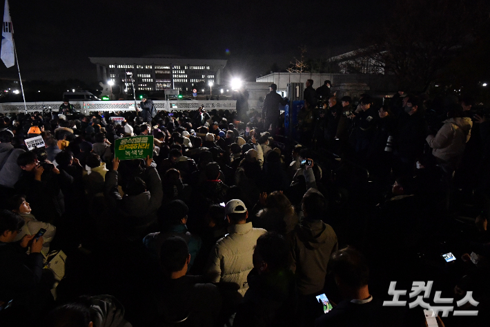 윤석열 대통령이 긴급 담화를 통해 비상계엄을 선포한 가운데 4일 새벽 서울 여의도 국회의사당 정문 앞에서 군·경찰과 대치하던 시민들이 비상계엄 해제 요구 결의안이 가결되자 환호하고 있다. 류영주 기자