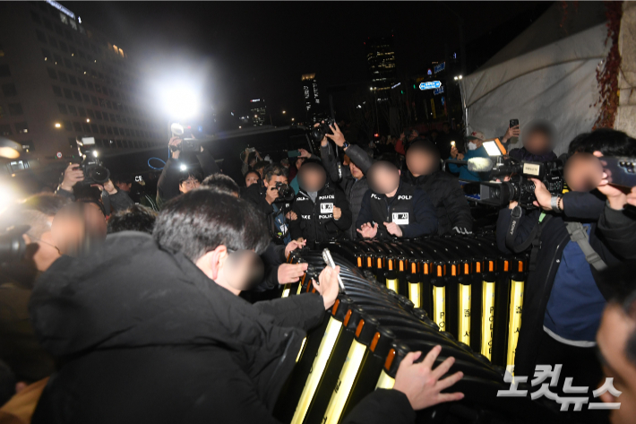 윤석열 대통령이 비상계엄을 선포한 3일 밤 서울 여의도 국회 출입문에서 국회 관계자와 경찰이 대치하고 있다. 박종민 기자