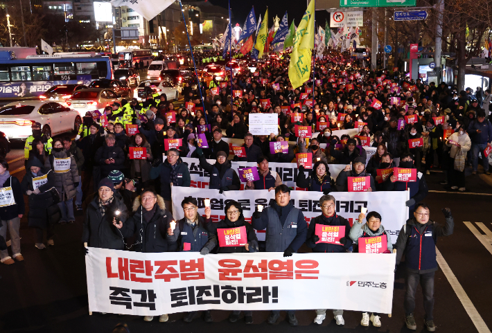  4일 오후 서울 동화면세점 앞에서 열린 '내란죄 윤석열 퇴진! 시민촛불'에서 전국민주노동조합총연맹 조합원을 비롯한 참석자들이 용산 대통령실 방향으로 행진하고 있다. 연합뉴스 