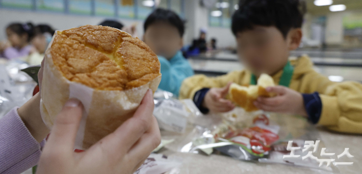 급식, 돌봄 등의 업무를 담당하는 학교 비정규직 노동자들이 파업에 참여하면서 급식 운영에 일부 차질이 생긴 가운데 6일 서울의 한 초등학교 급식실에서 학생들이 배식받은 빵과 음료로 점심을  먹고있다. 사진공동취재단