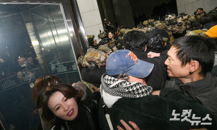 윤석열 대통령이 3일 밤 비상계엄을 선포한 가운데 4일 새벽 서울 여의도 국회에서 경내로 진입하려는 계엄군과 저지하려는 시민 및 국회 관계자들이 대치하고 있다. 박종민 기자