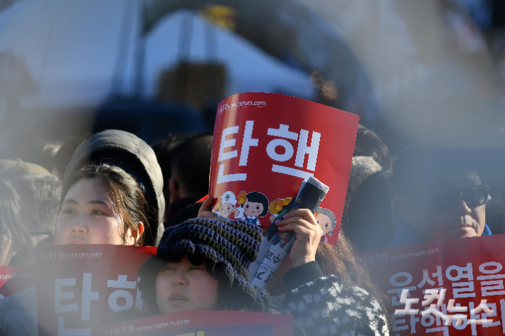 윤석열 대통령 탄핵소추안 표결을 앞둔 7일 서울 여의도 국회 앞에서 시민들이 윤 대통령 탄핵 구호를 외치고 있다. 박종민 기자