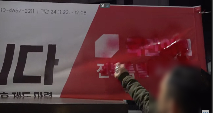 한 시민의 국민의힘 전북도당 당사 앞에서 당명을 지우고 있다. 전북CBS노컷뉴스 유튜브 캡처 