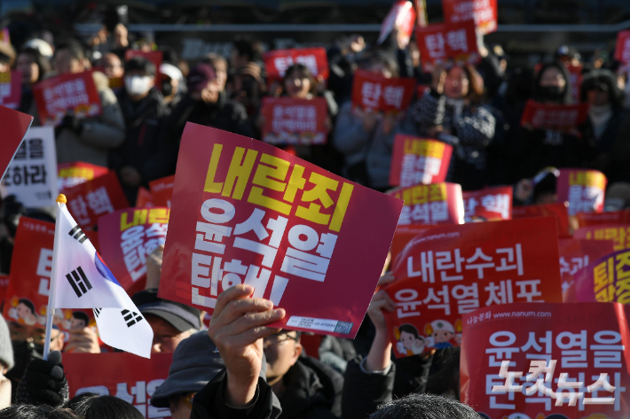 윤석열 대통령 탄핵소추안 표결을 앞둔 7일 서울 여의도 국회 앞에서 시민들이 윤 대통령 탄핵 구호를 외치고 있다. 박종민 기자