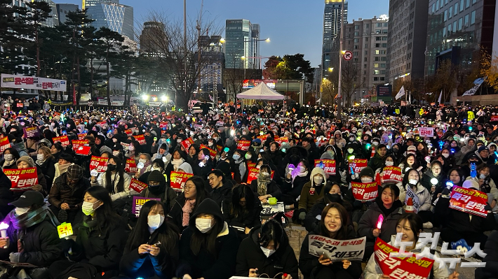 8일 서울 영등포구 국회의사당 역 앞에서 시민들이 응원봉을 들고 구호를 외치고 있다. 박인 기자