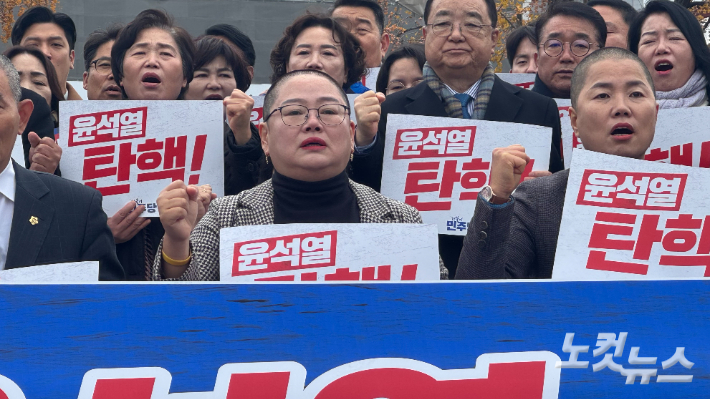 광주 동구의회 문선하 의장이 9일 오후 광주 동구 5·18민주광장에서 열린 '12·3 내란 사태 주범 윤석열 대통령 즉각 탄핵 및 국민의힘 규탄 공동 성명 발표'에 참석해 삭발식을 진행한 뒤 눈시울이 붉어진 채 구호를 제창하고 있다. 김수진 기자