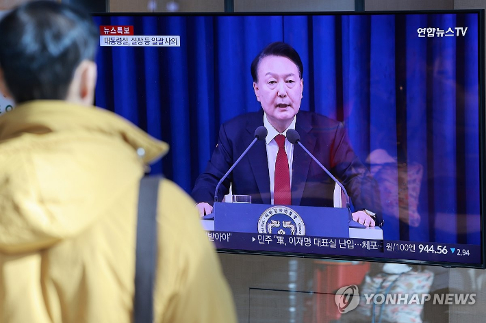 (서울=연합뉴스) 신현우 기자 = 윤석열 대통령이 비상계엄 선포를 해제한 4일 서울역 대합실에서 시민이 비상계엄 사태 관련 보도를 보고 있다.  연합뉴스