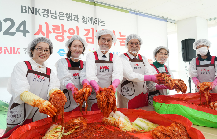 BNK경남은행 예경탁 은행장(사진 왼쪽 세번째)과 홍태용 김해시장(사진 오른쪽 세번째)이 김장나눔행사에 김장을 담그고 있다. 경남은행 제공