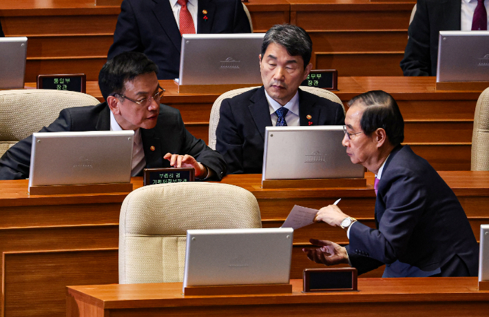 한덕수 국무총리가 10일 오후 국회에서 열린 본회의에서 최상목 경제부총리 겸 기획재정부 장관(왼쪽), 이주호 부총리 겸 교육부 장관과 논의하고 있다. 연합뉴스