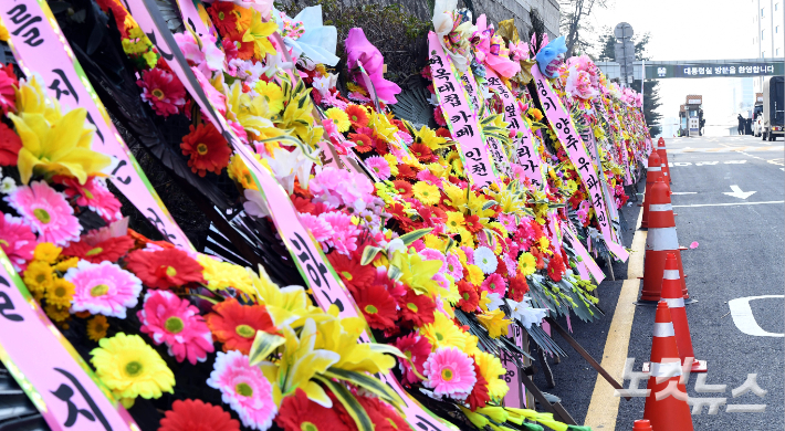 11일 오전 서울 용산구 대통령실·국방부 청사 앞에 윤석열 대통령을 응원하는 화환이 놓여 있다. 지지자들이 세워놓은 것으로 보이는 이 화환에는 '윤석열 대통령님 힘내세요', '계엄령은 대통령의 고유권한이다' 등 윤 대통령을 응원하는 문구의 리본이 부착돼 있다. 황진환 기자