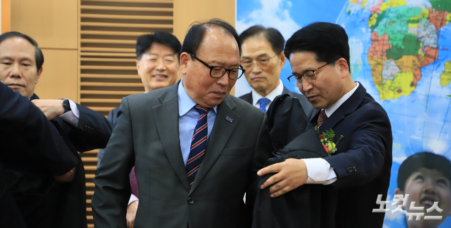 운암신안교회 강성철 목사가 임직받은 조영호 장로에게 가운을 입히고 있다. 한세민