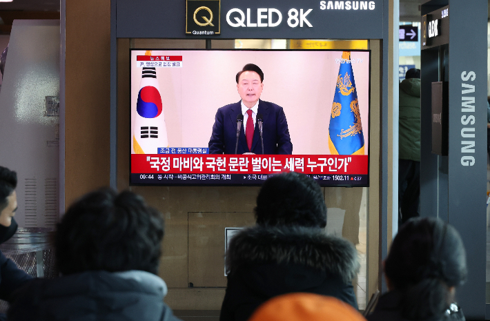 12일 오전 서울역에서 시민들이 윤석열 대통령 담화를 TV로 보고 있다. 연합뉴스