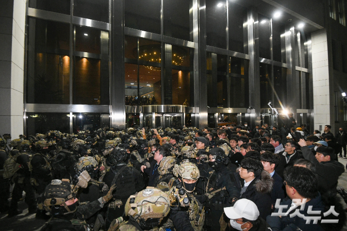 윤석열 대통령이 3일 밤 비상계엄을 선포한 가운데 4일 새벽 서울 여의도 국회에서 경내로 진입하려는 계엄군과 저지하려는 시민 및 국회 관계자들이 대치하고 있다. 박종민 기자