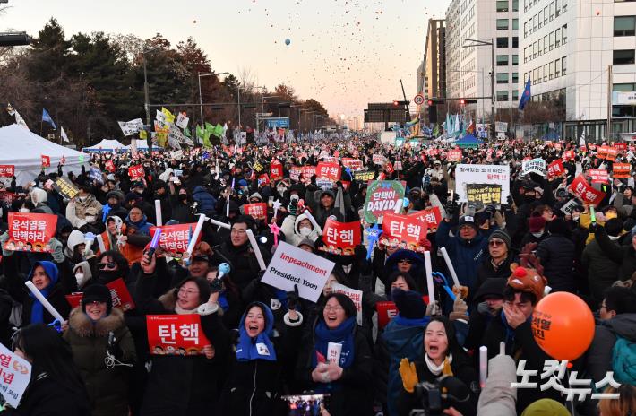 윤석열 대통령 탄핵소추안이 가결된 14일 서울 여의도 국회 앞에서 열린 촛불집회에 참석한 시민들이 탄핵이 가결되자 환호하고 있다.