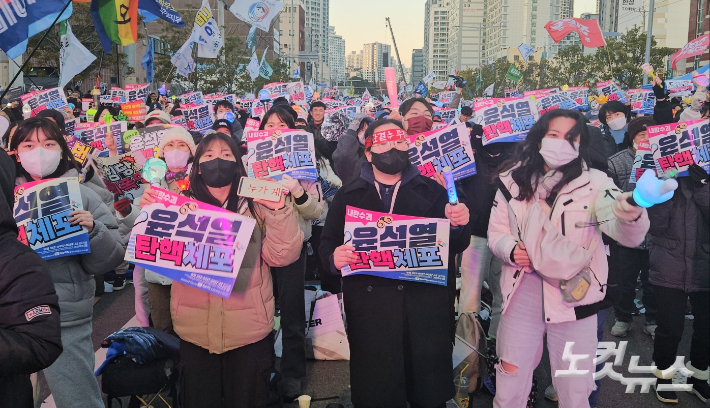 14일 국회에서 윤석열 대통령의 탄핵소추안이 가결되자 부산 시민들이 일제히 일어나 응원봉을 흔들며 환호하고 있다. 김혜민 기자 