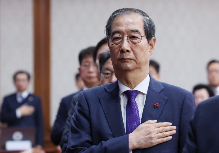 한덕수 대통령 권한대행 겸 국무총리가 17일 서울 종로구 정부서울청사에서 열린 국무회의에서 국기에 경례하고 있다. 연합뉴스