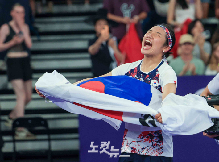 2024 파리올림픽 배드민턴 여자 단식 금메달을 따낸 안세영이 승리한 뒤 태극기를 들고 기뻐하는 모습. 2024.8.5 파리= 올림픽사진공동취재단/KO 황진환 기자