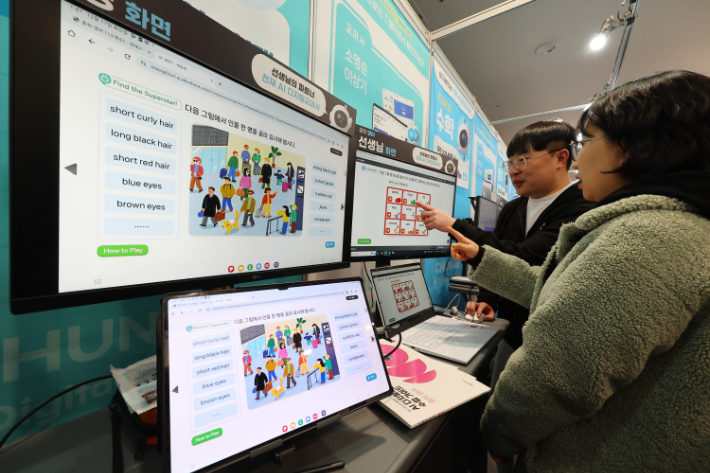 지난 17일 인천 연수구 송도컨벤시아에서 열린 '2024 인천디지털교육 페스티벌'에서 관계자들이 AI디지털교과서를 살펴보고 있다. 연합뉴스