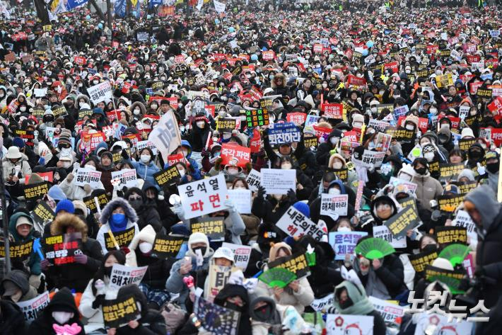 21일 오후 서울 종로구 경복궁 동십자각 앞에서 열린 범국민촛불대행진에서 시민들이 윤석열 대통령 즉각 체포 및 퇴진을 촉구하고 있다. 류영주 기자