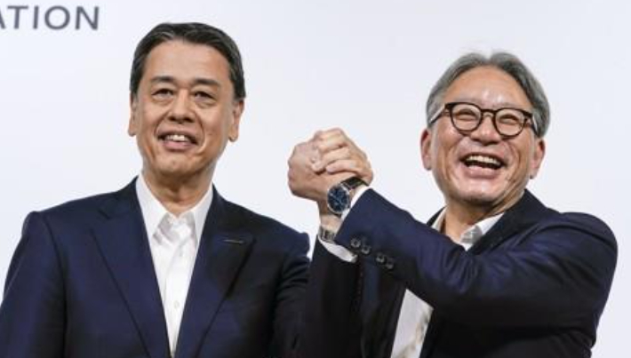 우치다 마코토 닛산자동차 사장(왼쪽)과 미베 도시히로 혼다자동차 사장이 지난 8월 1일 일본 도쿄에서 연 공동기자회견에서 손을 잡고 포즈를 취하고 있다. 연합뉴스