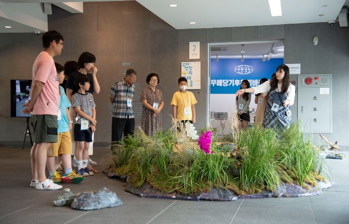 '우리라는 이름의 바다' 전시장에서 프로그램 참여자들이 전시설명을 듣고 있다. 경북대미술관 제공 