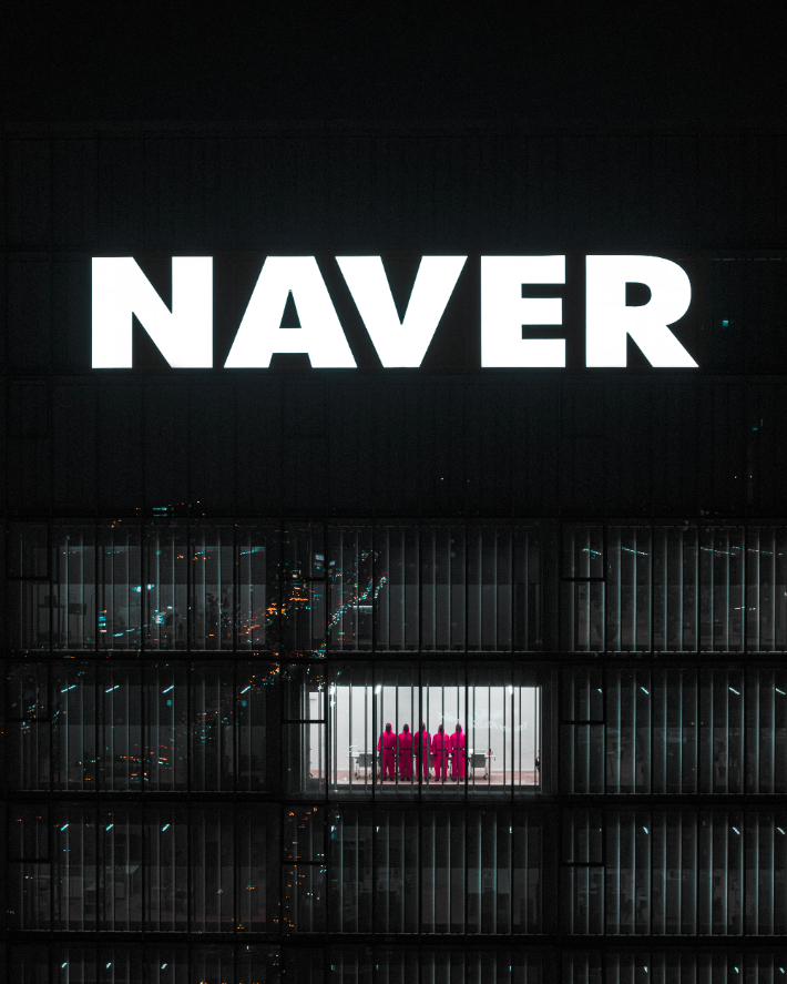 네이버 1784 사옥 안에서 '오징어게임'의 핑크가드들이 창밖을 향해 서있는 모습. 네이버 제공