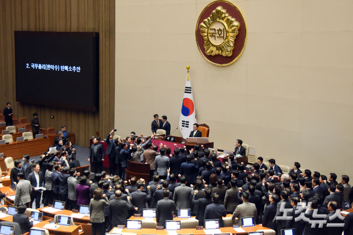 27일 서울 여의도 국회에서 열린 제420회국회(임시회) 제2차 본회의에서 우원식 국회의장이 국무총리(한덕수) 탄핵소추안 가결 의결정족수에 대한 설명(재적의원 과반수 찬성)을 하자 국민의힘 의원들이 의장석 주변으로 모여들며 항의를 하고 있다. 윤창원 기자