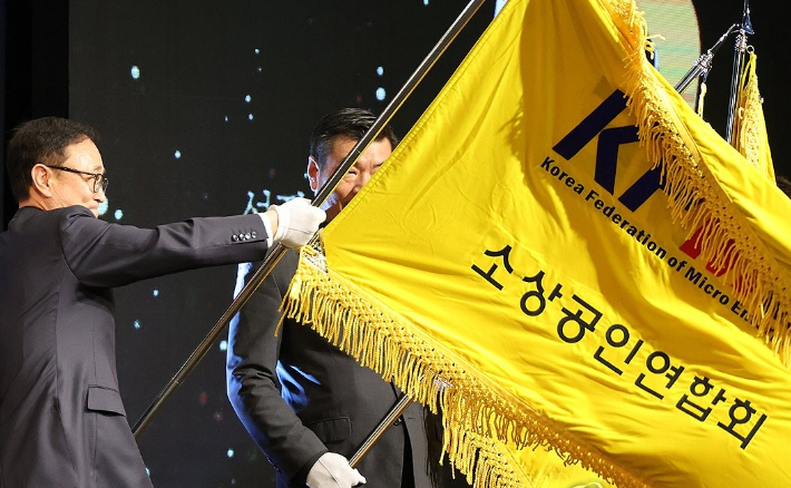 송치영 소상공인연합회장이 지난 11월 12일 서울 중소기업중앙회에서 열린 '소상공인연합회 창립 10주년 기념식 및 제5대 회장 취임식'에서 깃발을 흔들고 있다. 연합뉴스