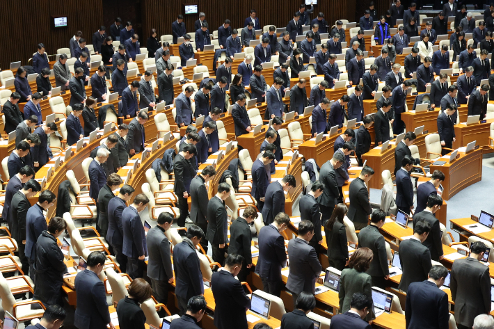 31일 오후 국회 본회의에서 우원식 국회의장을 비롯한 의원들이 제주항공 여객기 참사 희생자를 추모하며 묵념하고 있다. 연합뉴스