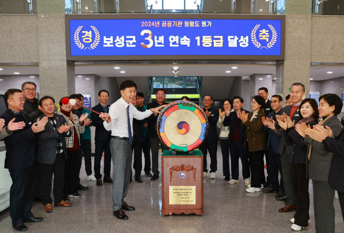 김철우 군수가 3년 연속 종합청렴도 1등급 달성을 자축하며 북을 치는 것을 함께 한 간부들이 반기며 박수치고 있다. 보성군 제공