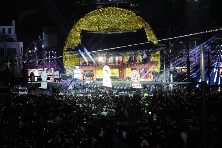 새해 첫날인 1일 오전 서울 종로구 보신각에서 열린 제야의 종 타종행사에서 시민대표들의 타종하는 가운데 보신각 뒤로 자정의 태양이 떠오르고 있다. 연합뉴스