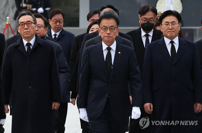 (서울=연합뉴스) 홍해인 기자 = 최상목 대통령 권한대행 부총리 겸 기획재정부 장관이 2025년 새해 첫날인 1일 국립서울현충원을 찾아 현충탑 참배를 마친 뒤 이동하고 있다.      최 권한대행 오른쪽 뒤로 이날 참배에 동행한 정진석 대통령 비서실장의 모습이 보인다. 2025.1.1 [대통령실통신사진기자단] hihong@yna.co.kr 연합뉴스