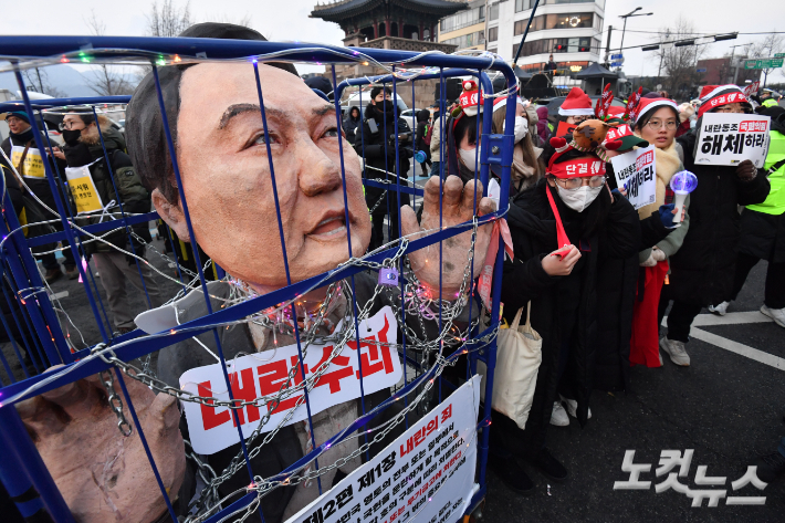 국회의 탄핵소추안 가결 이후 처음 맞는 주말인 지난해 12월 21일 오후 서울 종로구 경복궁 동십자각 앞에서 열린 범국민촛불대행진에서 시민들이 윤석열 대통령 즉각 체포 및 퇴진을 촉구하고 있다. 류영주 기자