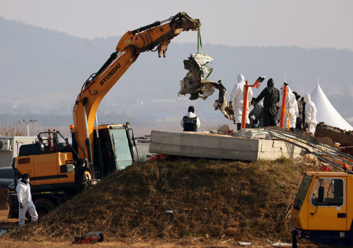 2일 오전 전남 무안국제공항 제주항공 참사 현장에서 합동조사단 관계자들이 방위각 시설(로컬라이저) 둔덕에 박힌 기체를 수거하고 있다. 연합뉴스