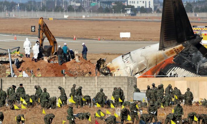 2일 오후 전남 무안군 무안국제공항 제주항공 참사 현장에서 합동조사단 관계자들이 로컬라이저 둔덕에 파묻힌 엔진을 꺼내는 작업을 하고 있다. 연합뉴스