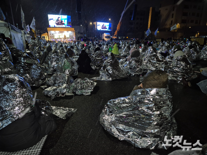 5일 오전 영하권으로 떨어진 체감 온도에도 집회 참가자들은 은박 담요, 우비, 우산 등 방한용품으로 추위를 견디며 매서운 눈발 속에서 자리를 지켰다. 박희영 기자